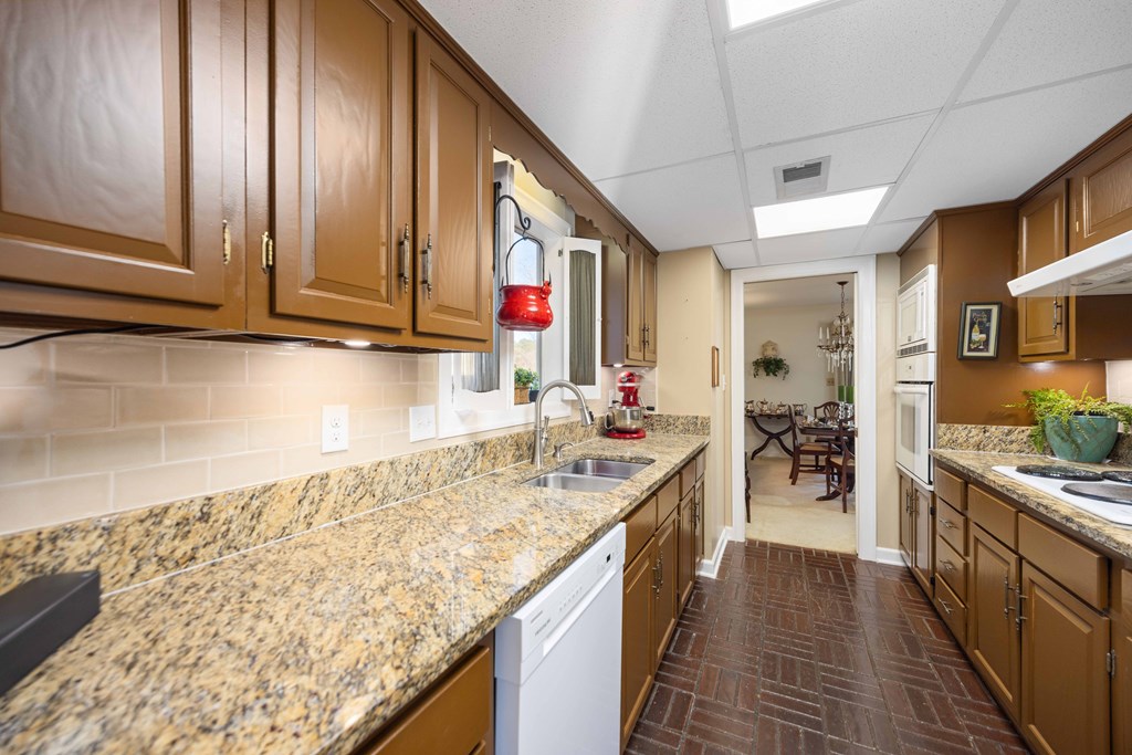 13965 Cross Creek Road Upatoi, GA 31829 - Photo 19 of 44 a kitchen with stainless steel appliances granite countertop a sink stove and cabinets