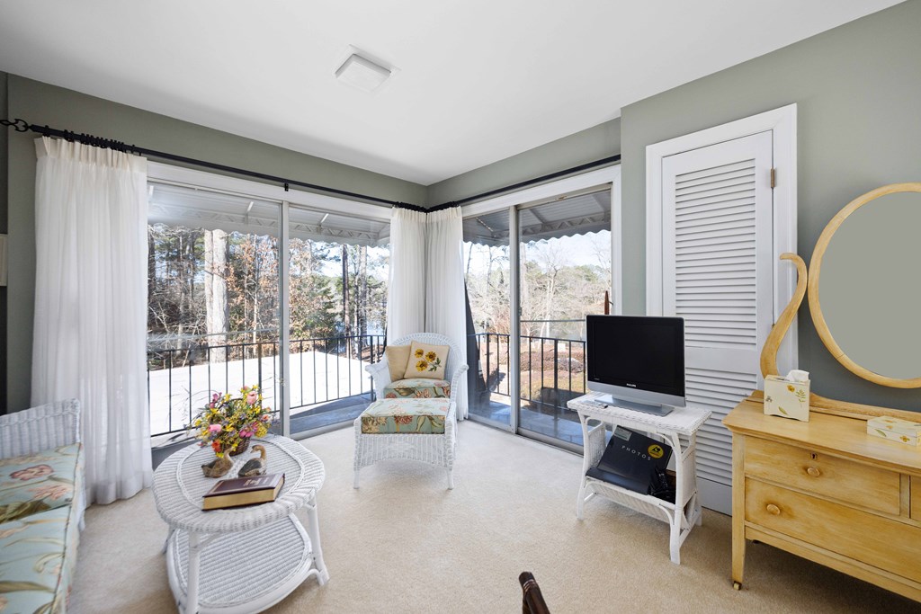 13965 Cross Creek Road Upatoi, GA 31829 - Photo 31 of 44 a living room with furniture a flat screen tv and a floor to ceiling window