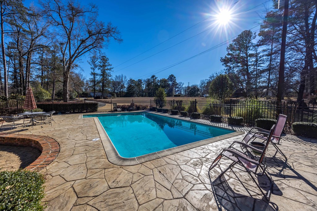 13965 Cross Creek Road Upatoi, GA 31829 - Photo 7 of 44 a view of a swimming pool with lounge chair and trees in the background