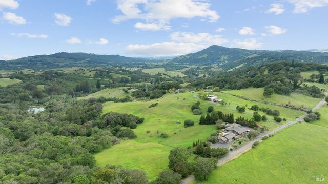 a view of a lush green hillside and houses