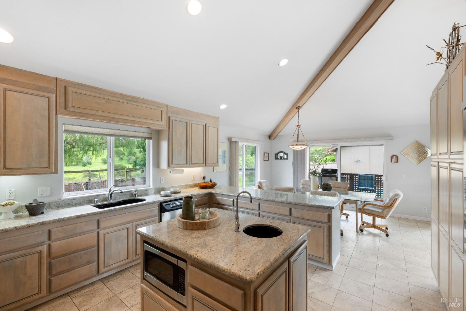 127 Mountain Meadow Lane Santa Rosa, CA 95404 - Photo 8 of 24 a kitchen with a stove a sink a kitchen island with a dining table and chairs