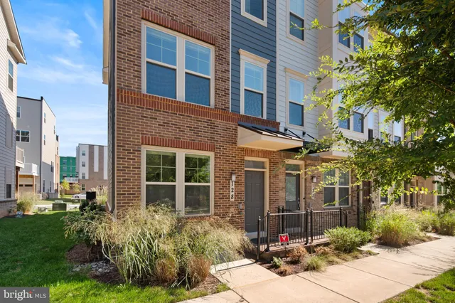 a view of a brick house with a yard and large tree