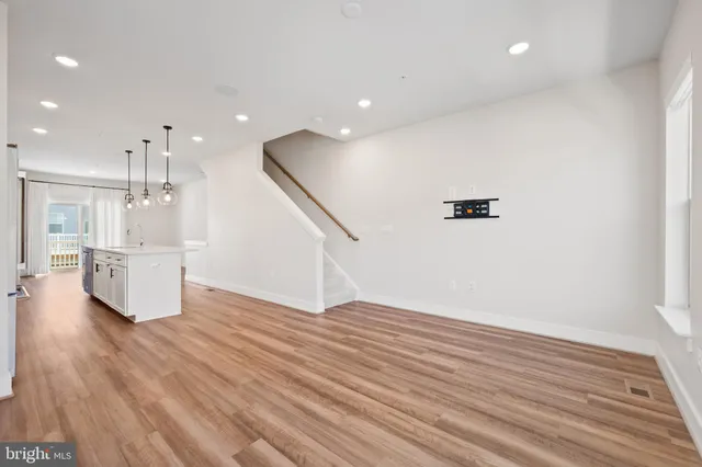 a view of a big room with wooden floor and windows