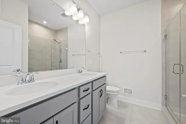 a bathroom with a sink a toilet a light fixture and a mirror