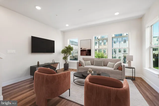 a living room with furniture a flat screen tv and a large window