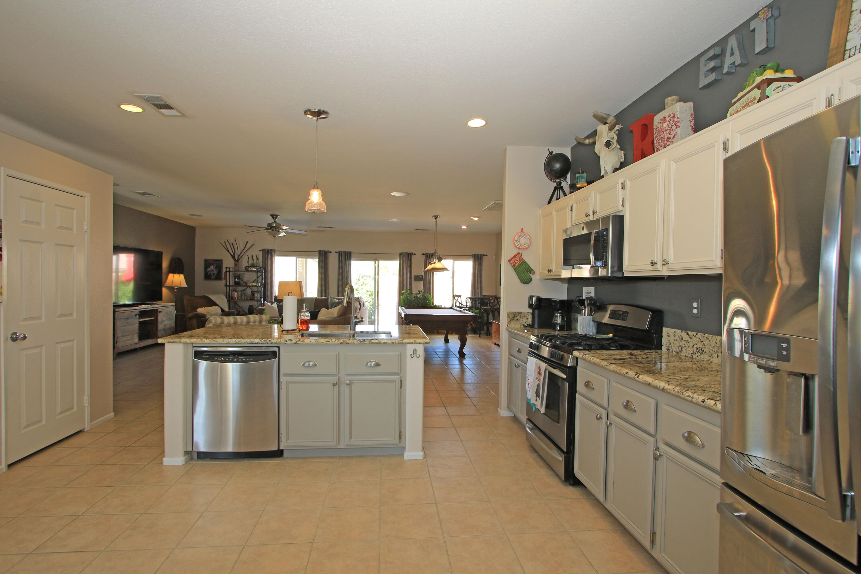 40651 Morris Street Indio, CA 92203 - Photo 14 of 47 a kitchen with stainless steel appliances a sink a stove top oven a refrigerator cabinets and a dining table