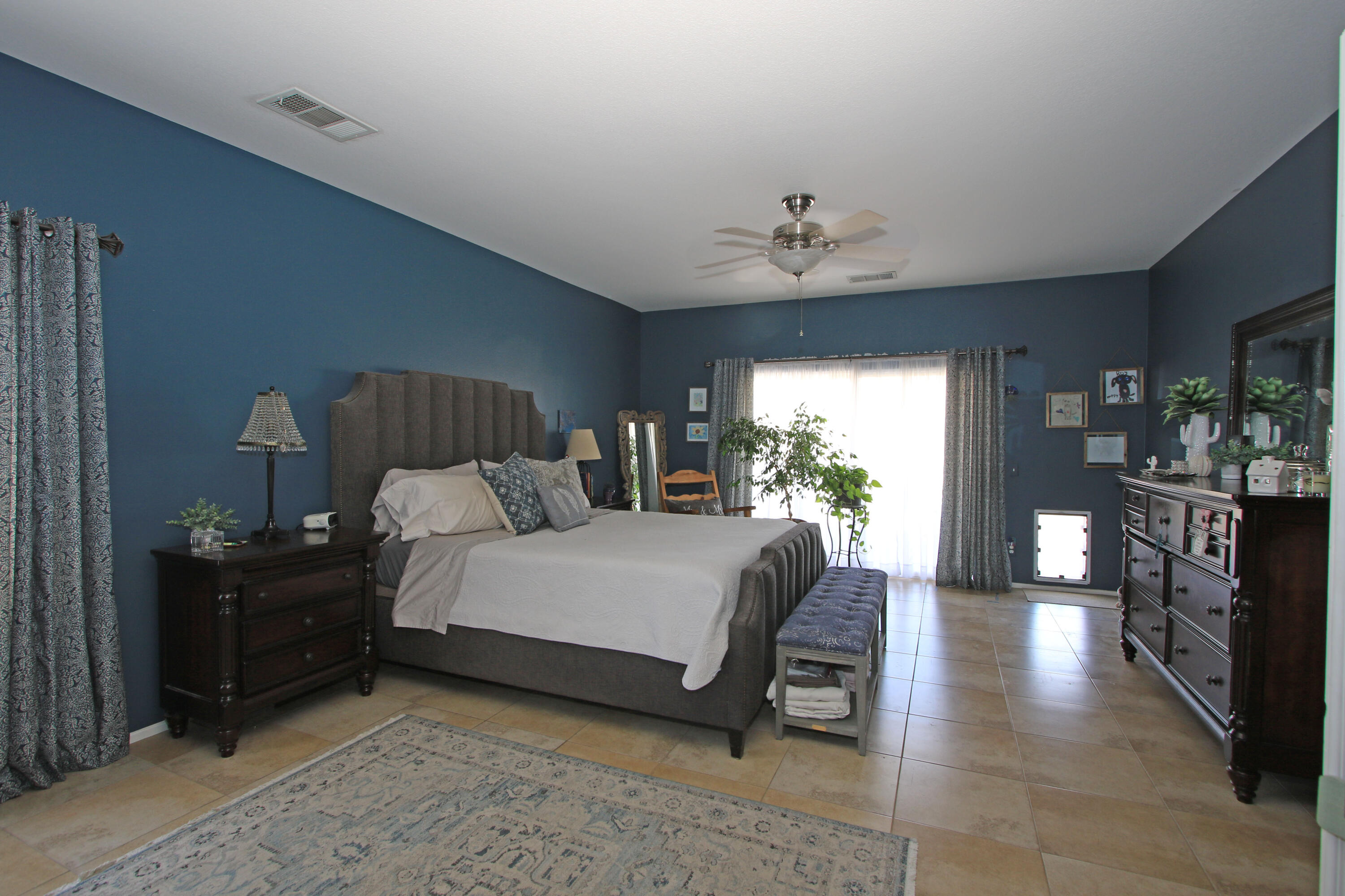 40651 Morris Street Indio, CA 92203 - Photo 22 of 47 a spacious bedroom with a bed and a chandelier