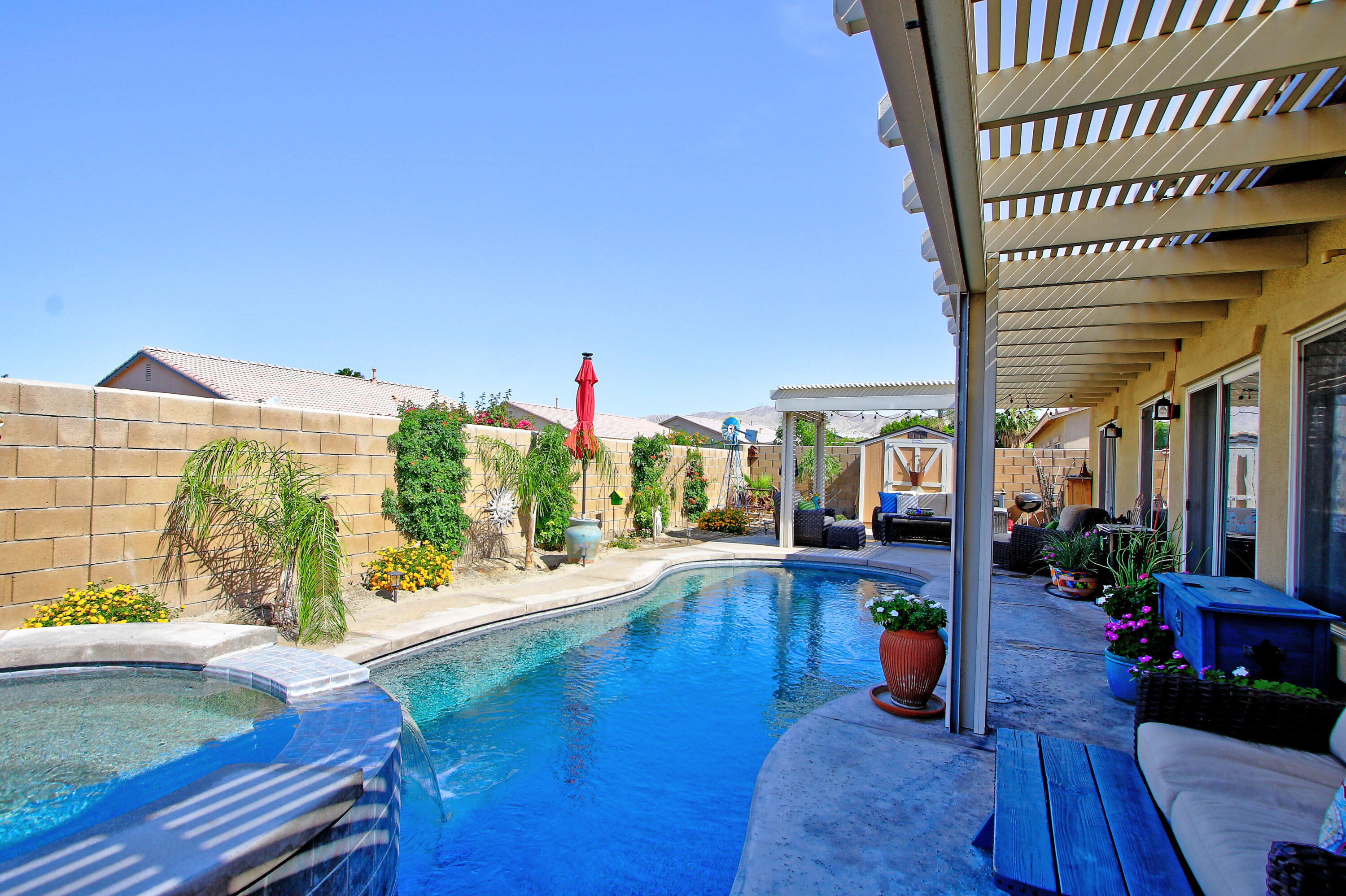 40651 Morris Street Indio, CA 92203 - Photo 29 of 47 a view of a patio with dining table and chairs under an umbrella with wooden floor
