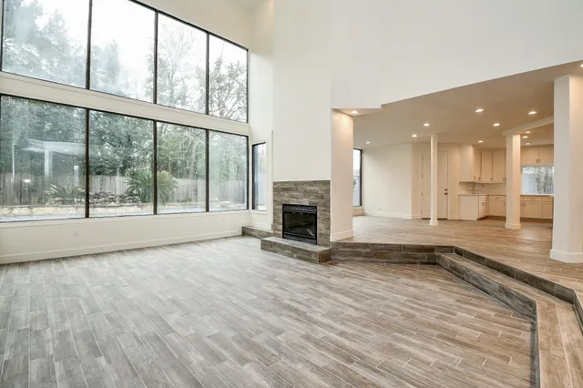 an empty room with wooden floor and a fireplace