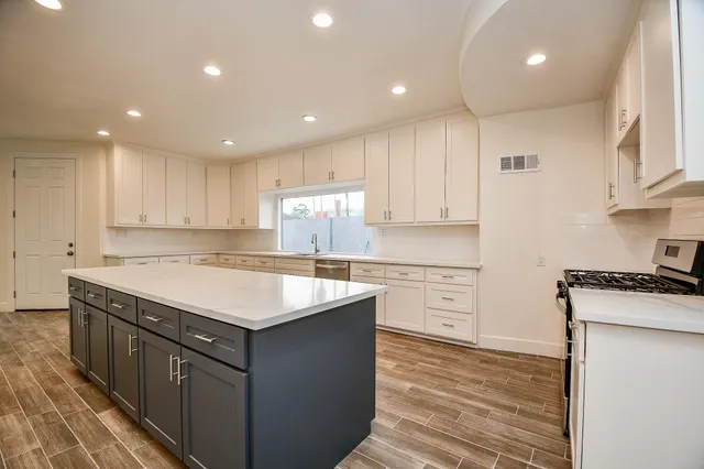 a kitchen with a stove a sink a refrigerator and cabinets