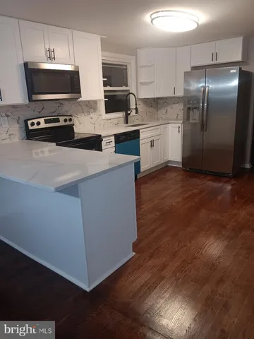 a kitchen with stainless steel appliances a stove a sink and a refrigerator