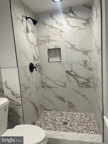 a bathroom with a toilet and a shower