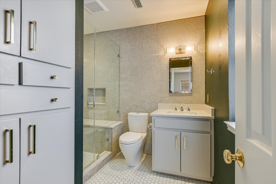 1208 East 13th Street Austin, TX 78702 - Photo 9 of 12 Full bath featuring vanity, a shower stall, light tile patterned floors, and tile walls