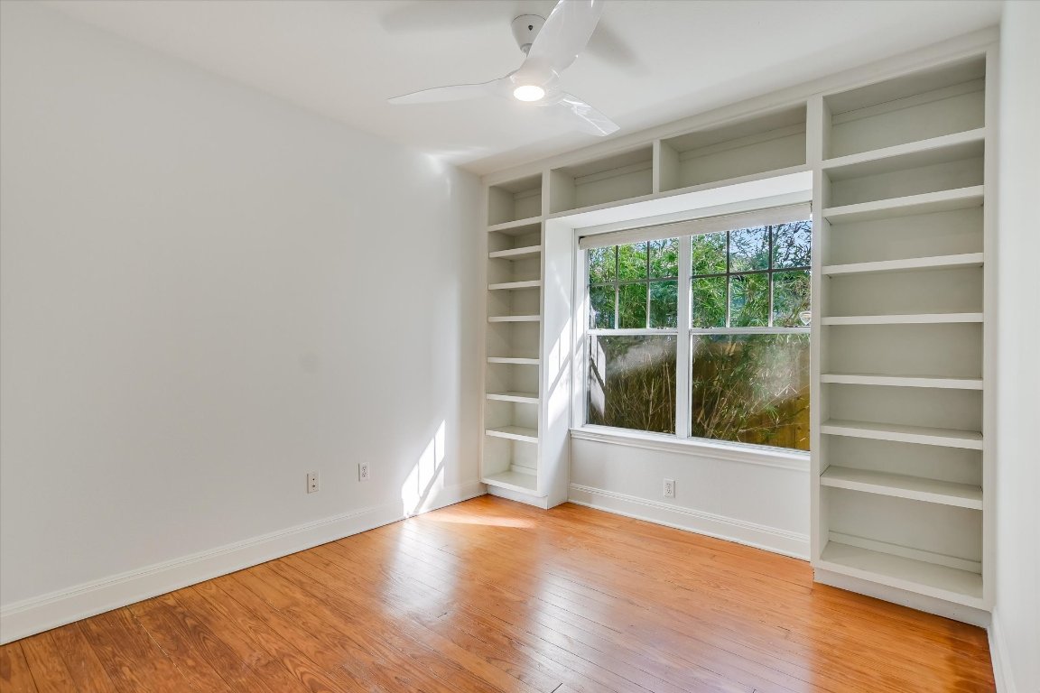 1208 East 13th Street Austin, TX 78702 - Photo 10 of 12 Empty room with built in features, ceiling fan, and light wood-style floors