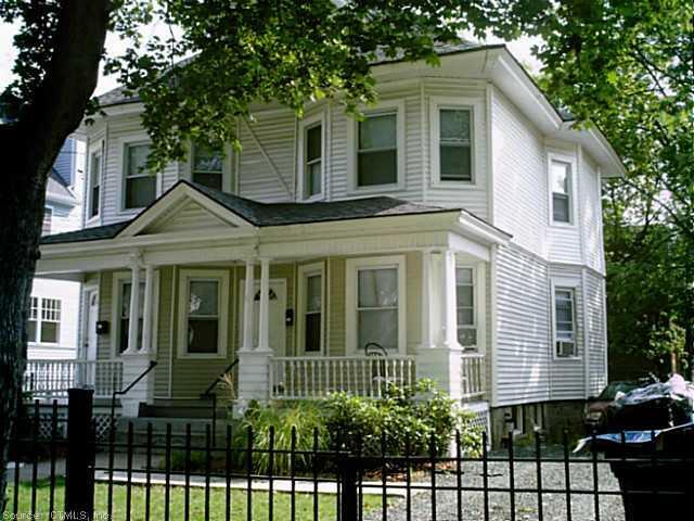 44 Irving Street Hartford, CT 06112 - Photo 1 of 1 a view of a white house with large windows and a small yard