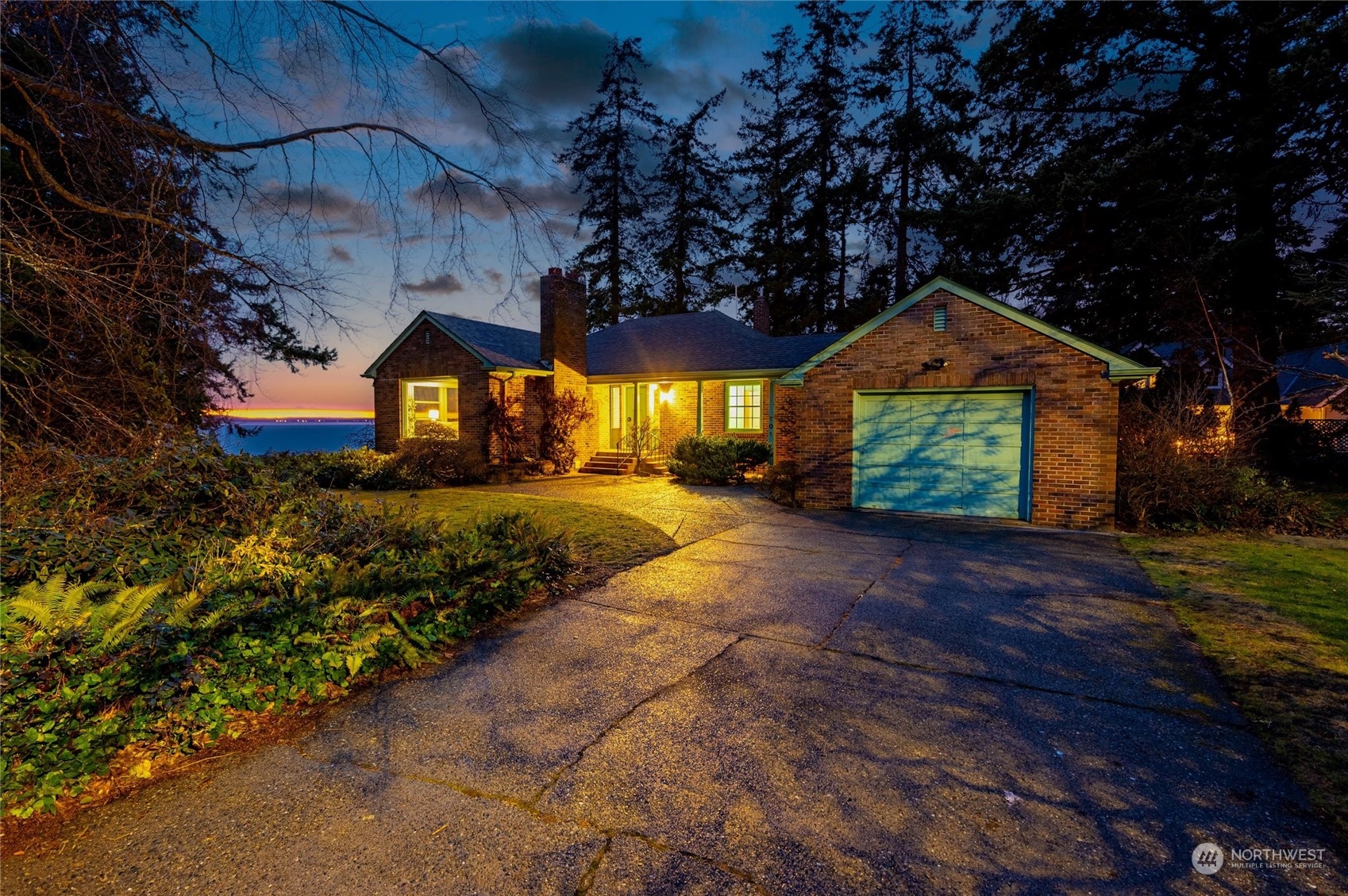 a front view of a house with a yard and large trees