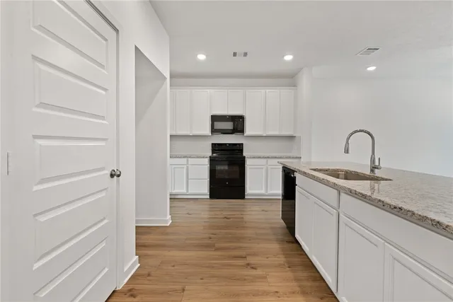 a kitchen with a refrigerator and a stove top oven