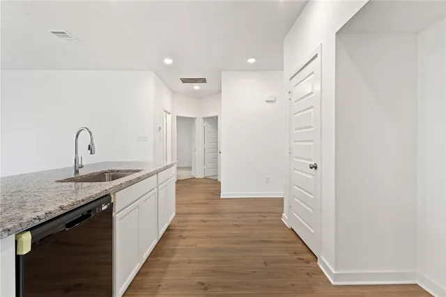 a kitchen with granite countertop a sink and cabinets