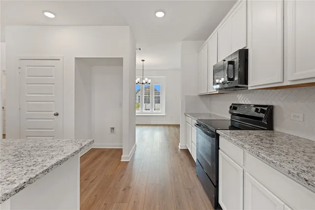 a kitchen with stainless steel appliances granite countertop a stove and a wooden cabinets