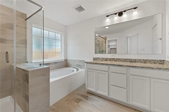 a bathroom with a tub a sink and mirror