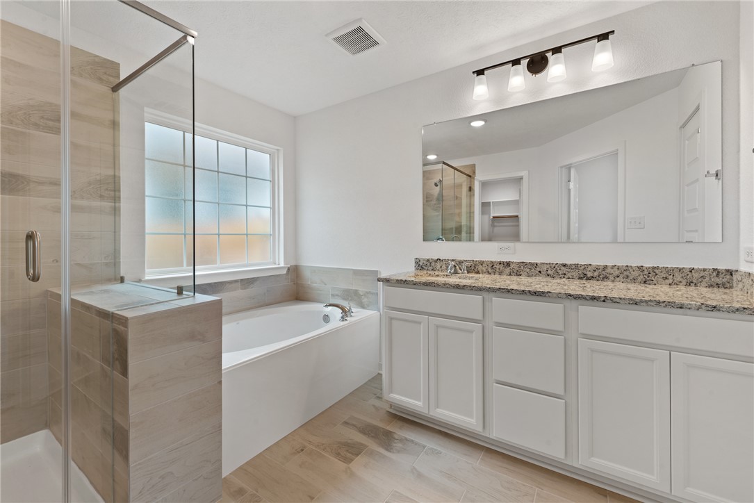 2426 Rooke Road Bryan, TX 77807 - Photo 34 of 39 a bathroom with a tub a sink and mirror