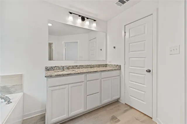 a bathroom with a granite countertop sink and a mirror