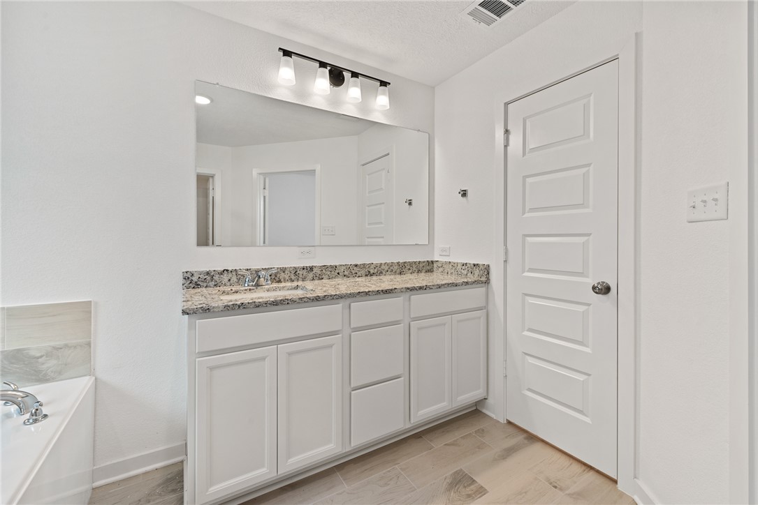 2426 Rooke Road Bryan, TX 77807 - Photo 36 of 39 a bathroom with a granite countertop sink and a mirror