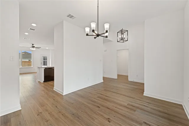 a view of a room with wooden floor staircase and kitchen view