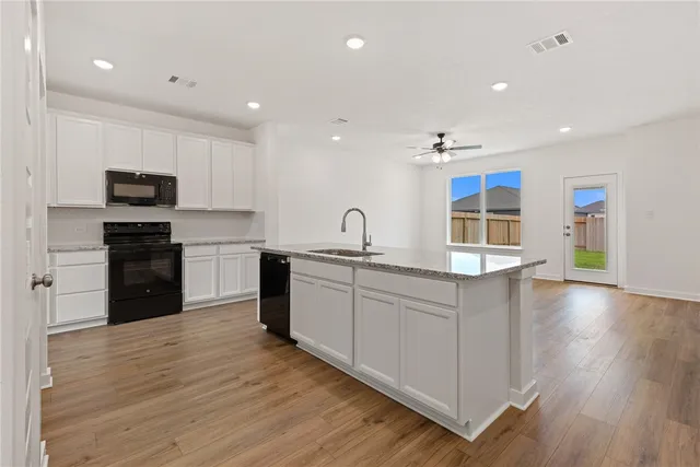 a kitchen with stainless steel appliances granite countertop a sink and cabinets