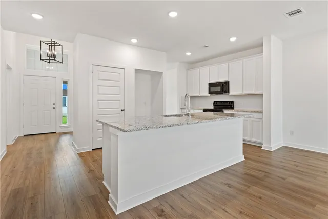 a kitchen with stainless steel appliances a refrigerator and a stove top oven