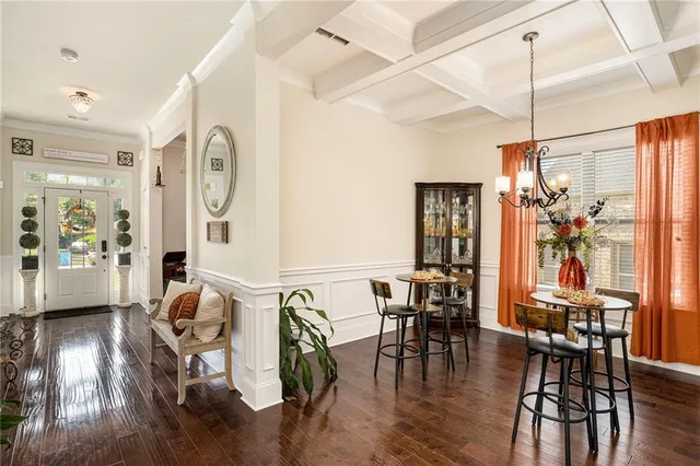 a large kitchen with stainless steel appliances a stove center island a oven a dining table and chairs with wooden floor