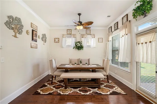 a living room with furniture a large window and wooden floor
