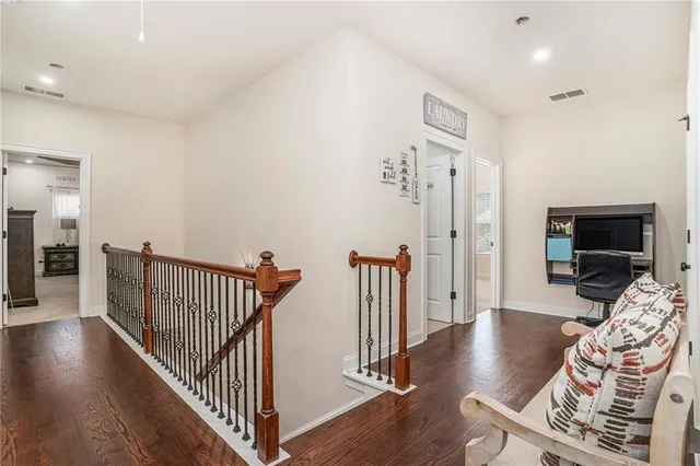 a view of a livingroom with wooden floor and a flat screen tv
