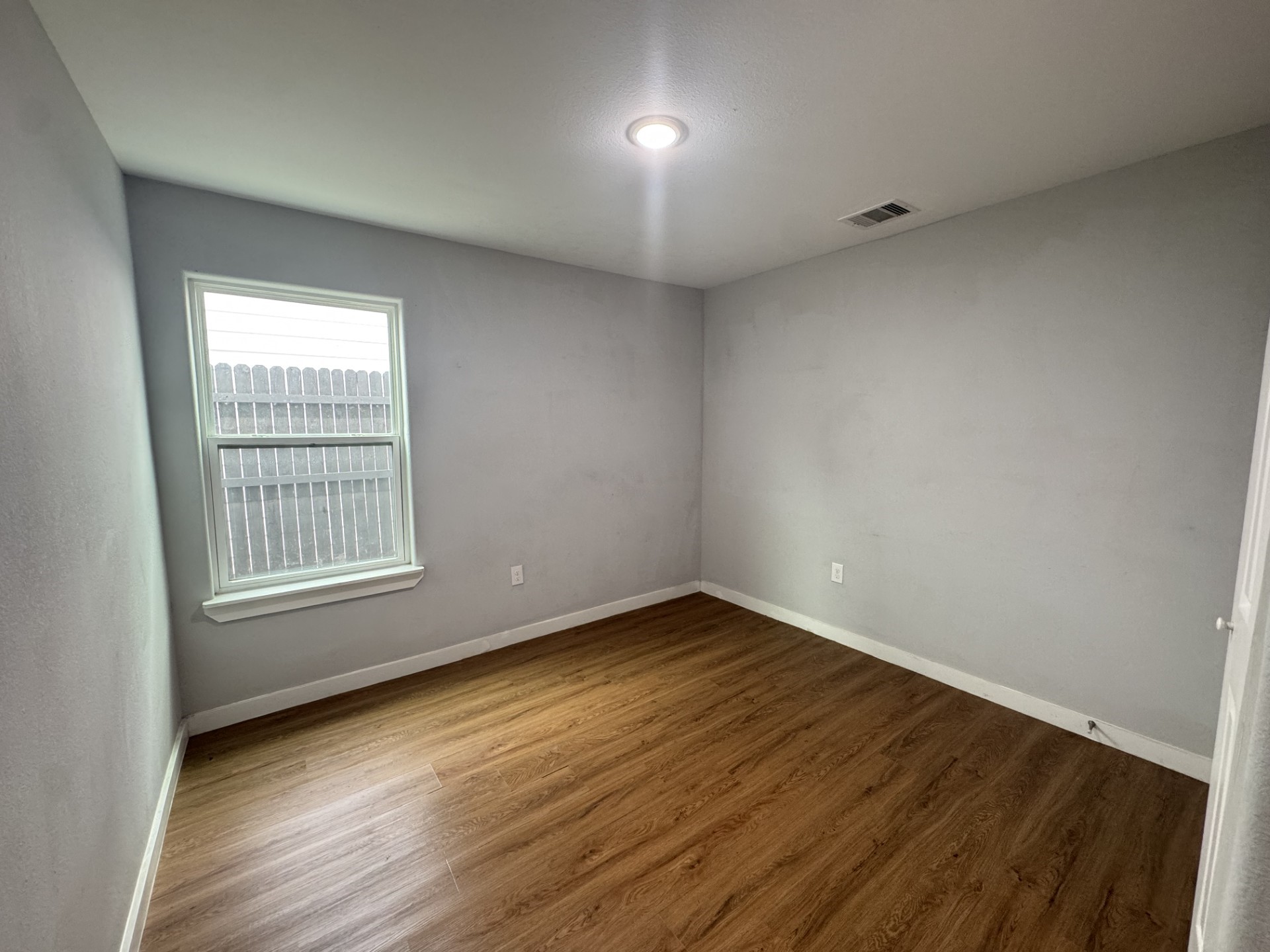 6606 Haight Street Houston, TX 77028 - Photo 12 of 23 a view of an empty room with wooden floor and a window