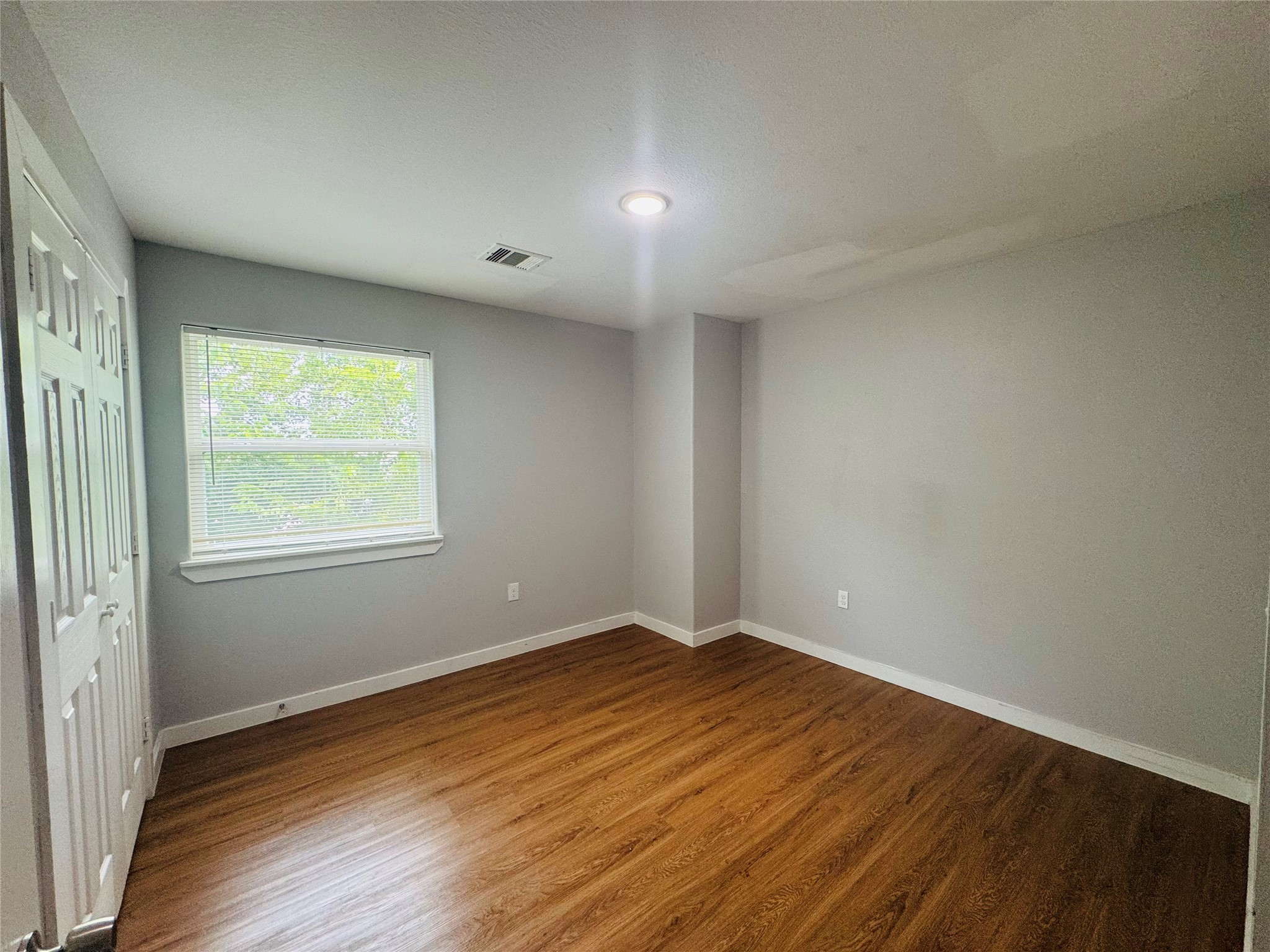 6606 Haight Street Houston, TX 77028 - Photo 5 of 23 a view of an empty room with wooden floor and a window