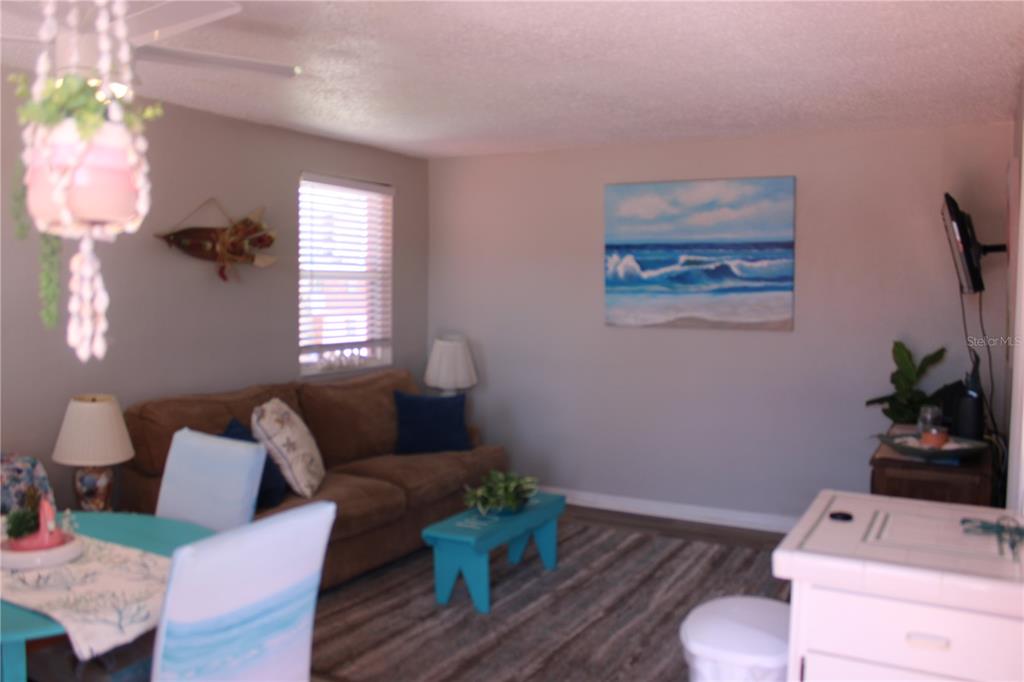 6800 Sunset Way, Unit 1708 St. Pete Beach, FL 33706 - Photo 6 of 15 a living room with furniture and a potted plant