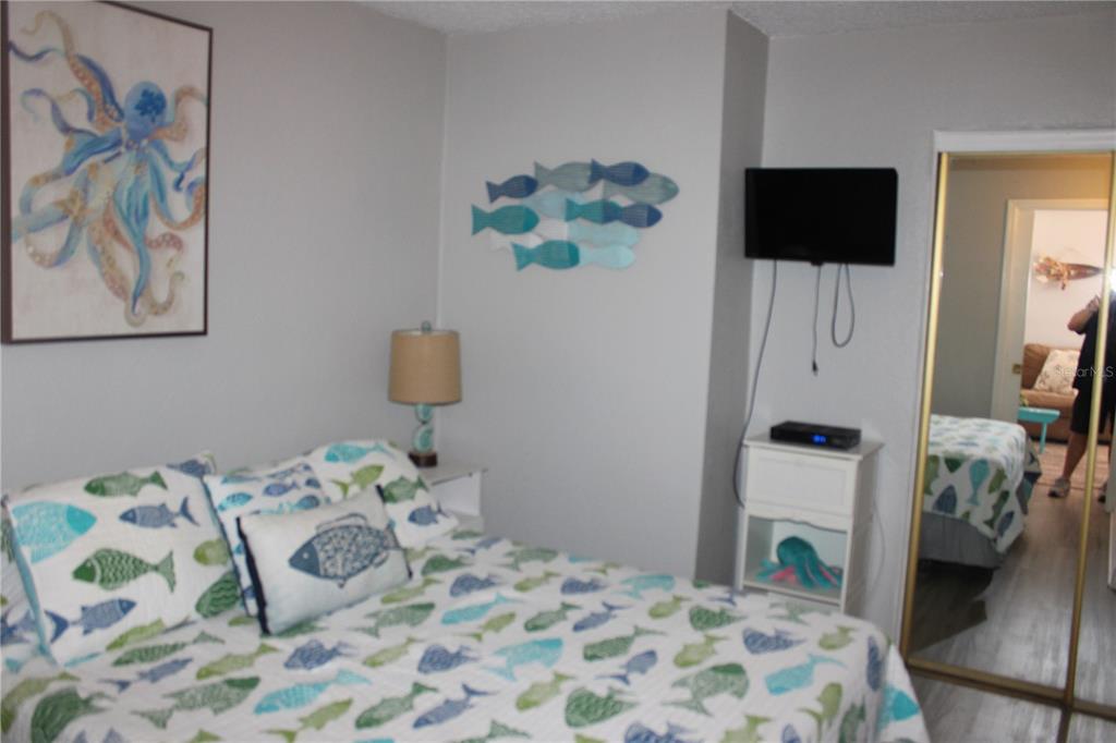 6800 Sunset Way, Unit 1708 St. Pete Beach, FL 33706 - Photo 9 of 15 a bedroom with a bed and a television
