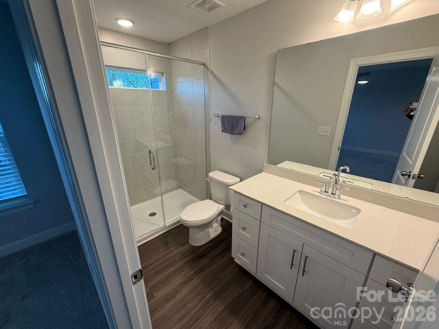 5593 Stafford Road Charlotte, NC 28215 - Photo 11 of 23 a bathroom with a sink a toilet and a large mirror