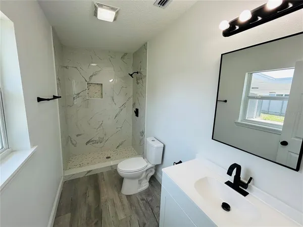 a bathroom with a sink a toilet and a mirror
