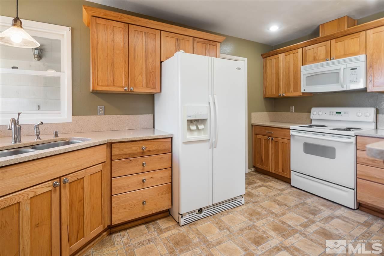 13100 Fellowship Way Reno, NV 89511 - Photo 10 of 40 a kitchen with white cabinets and white appliances