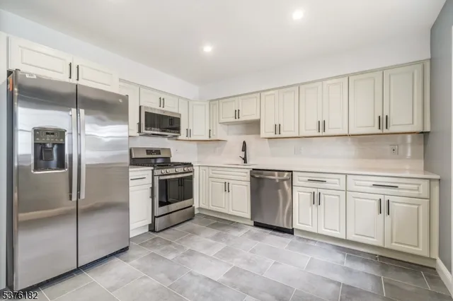 a kitchen with cabinets stainless steel appliances and a counter top space