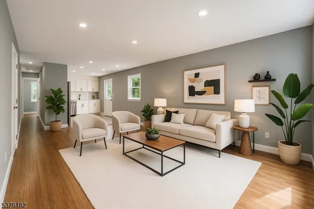 a living room with furniture a potted plant and kitchen view