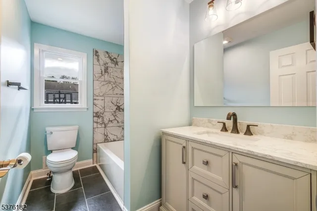 a bathroom with a granite countertop toilet sink and a mirror