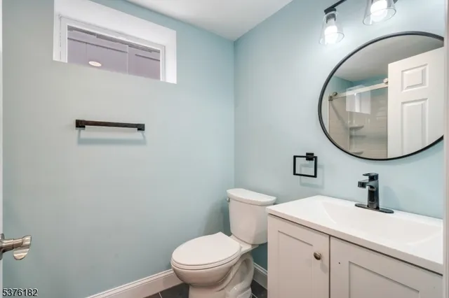 a bathroom with a sink mirror and toilet