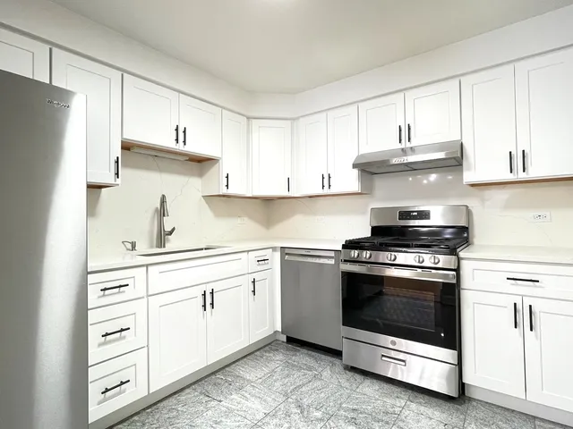 a kitchen with cabinets stainless steel appliances and sink