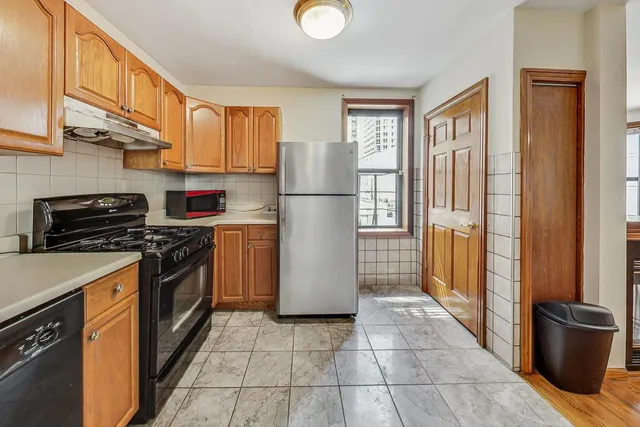 a kitchen with a refrigerator and a stove top oven