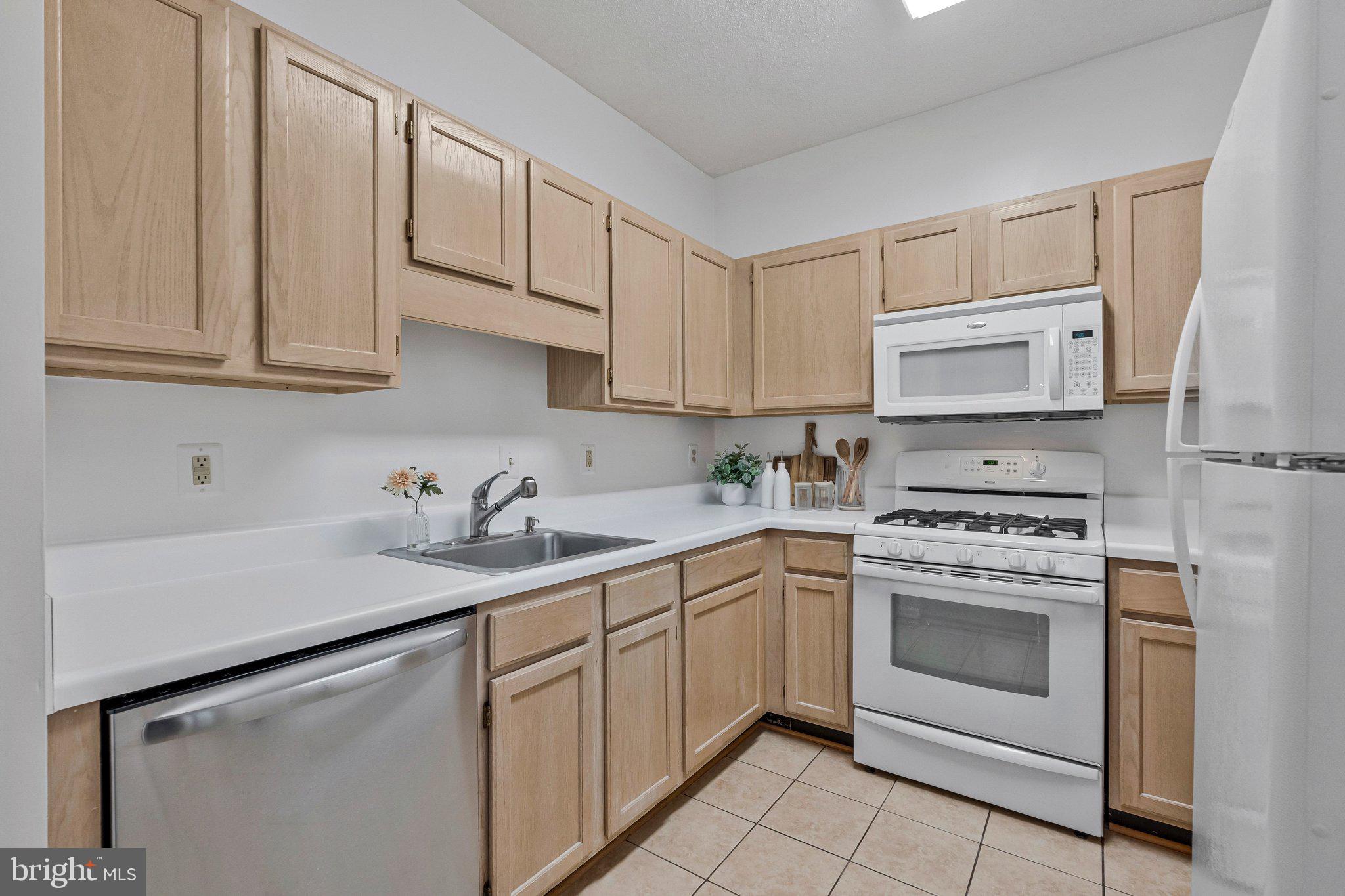 1720 Lake Shore Crest Drive, Unit 26 Reston, VA 20190 - Photo 13 of 38 a kitchen with cabinets appliances a sink and a counter top space