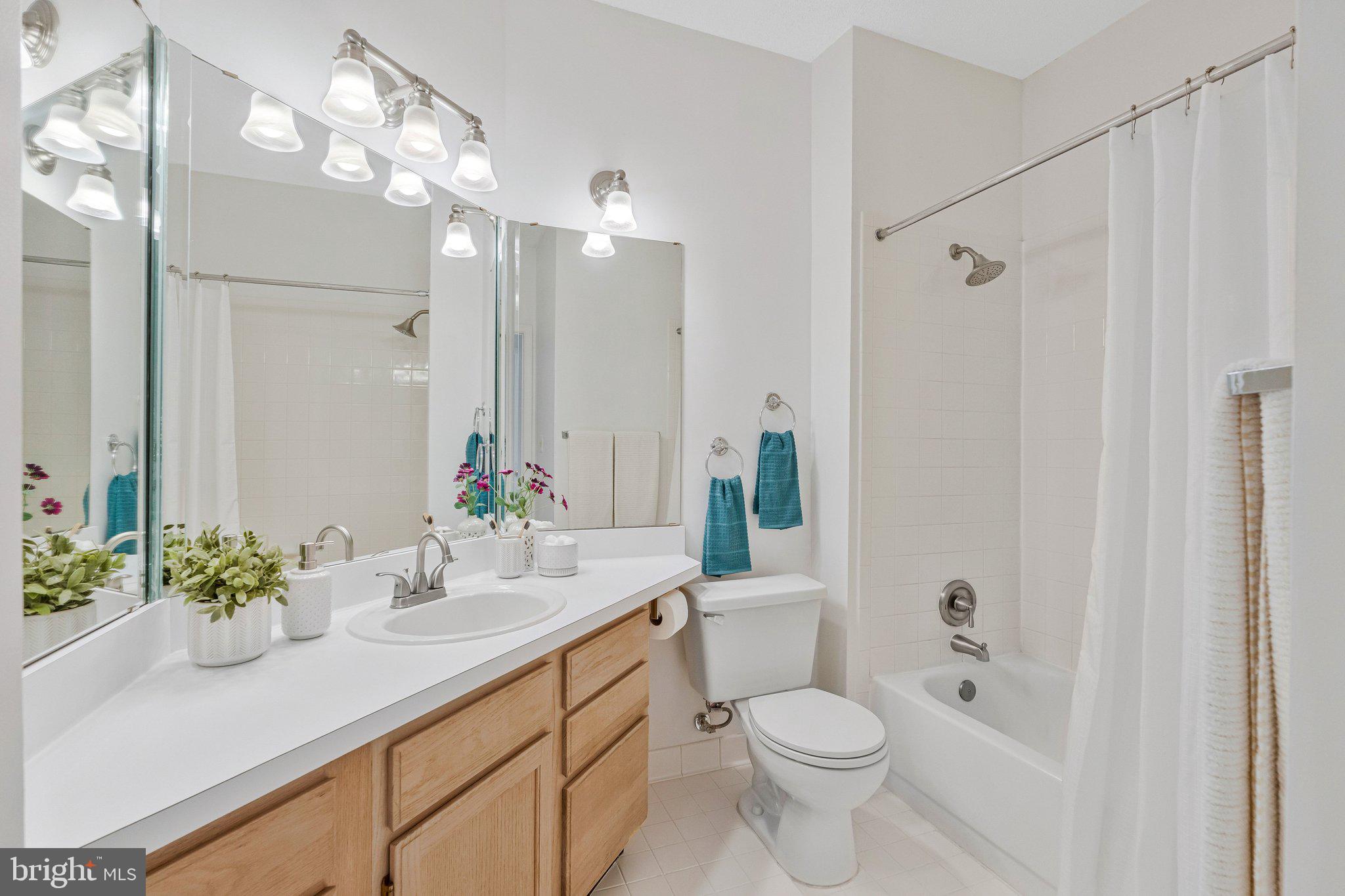 1720 Lake Shore Crest Drive, Unit 26 Reston, VA 20190 - Photo 17 of 38 a bathroom with a sink a toilet a mirror a vanity and shower