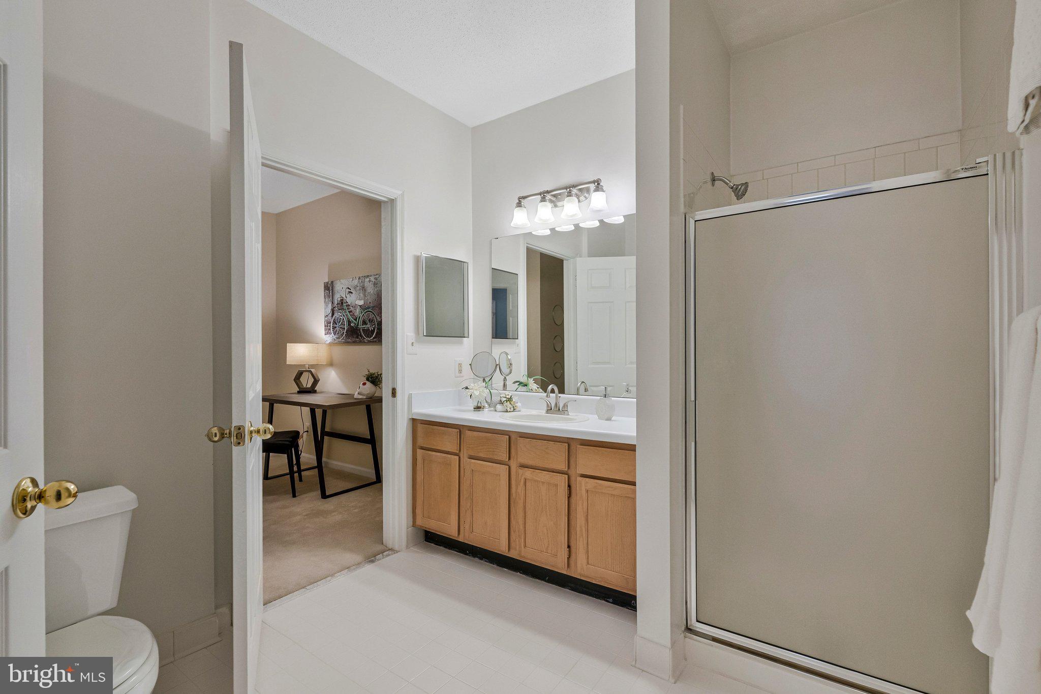 1720 Lake Shore Crest Drive, Unit 26 Reston, VA 20190 - Photo 21 of 38 a bathroom with a granite countertop sink a toilet and shower