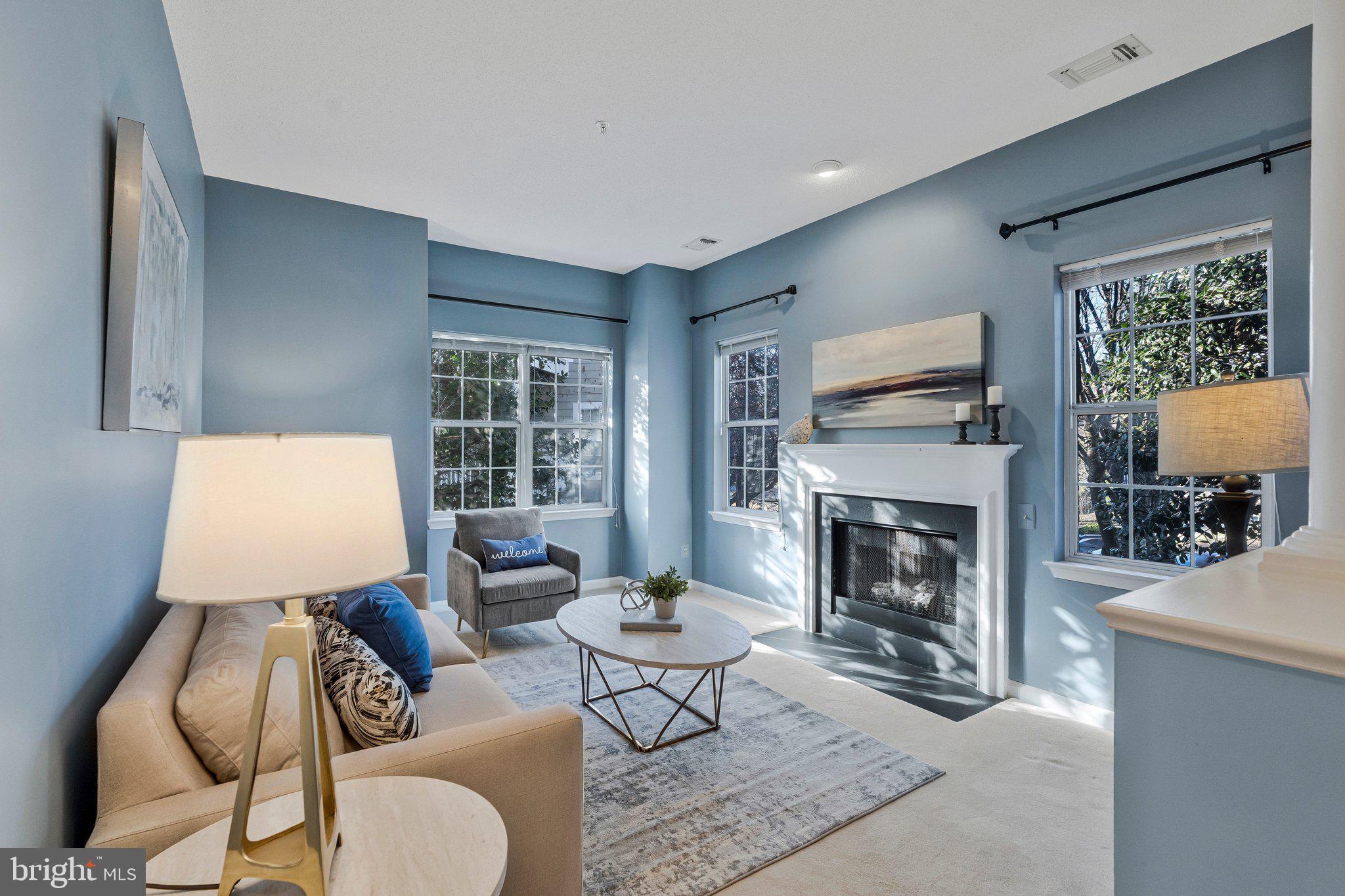 1720 Lake Shore Crest Drive, Unit 26 Reston, VA 20190 - Photo 5 of 38 a living room with furniture a fireplace and a large window